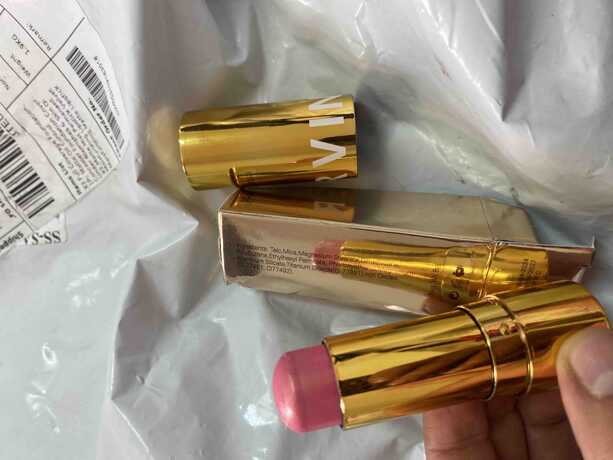 แท่งไฮไลท์สีทอง 2 แท่ง วางคู่กัน และมีภาพสวอชสีบนผิวหนังแสดงให้เห็นว่าเนื้อผลิตภัณฑ์ให้สีและประกายแบบไหน